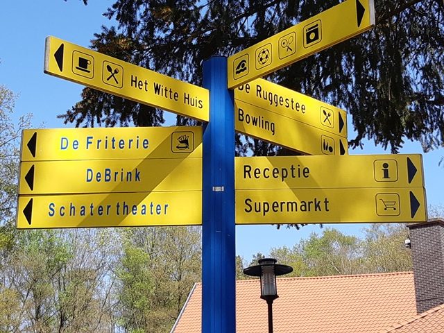 Wegwijzer op 't Veluws Hof naar de receptie, de supermarkt en de restaurants